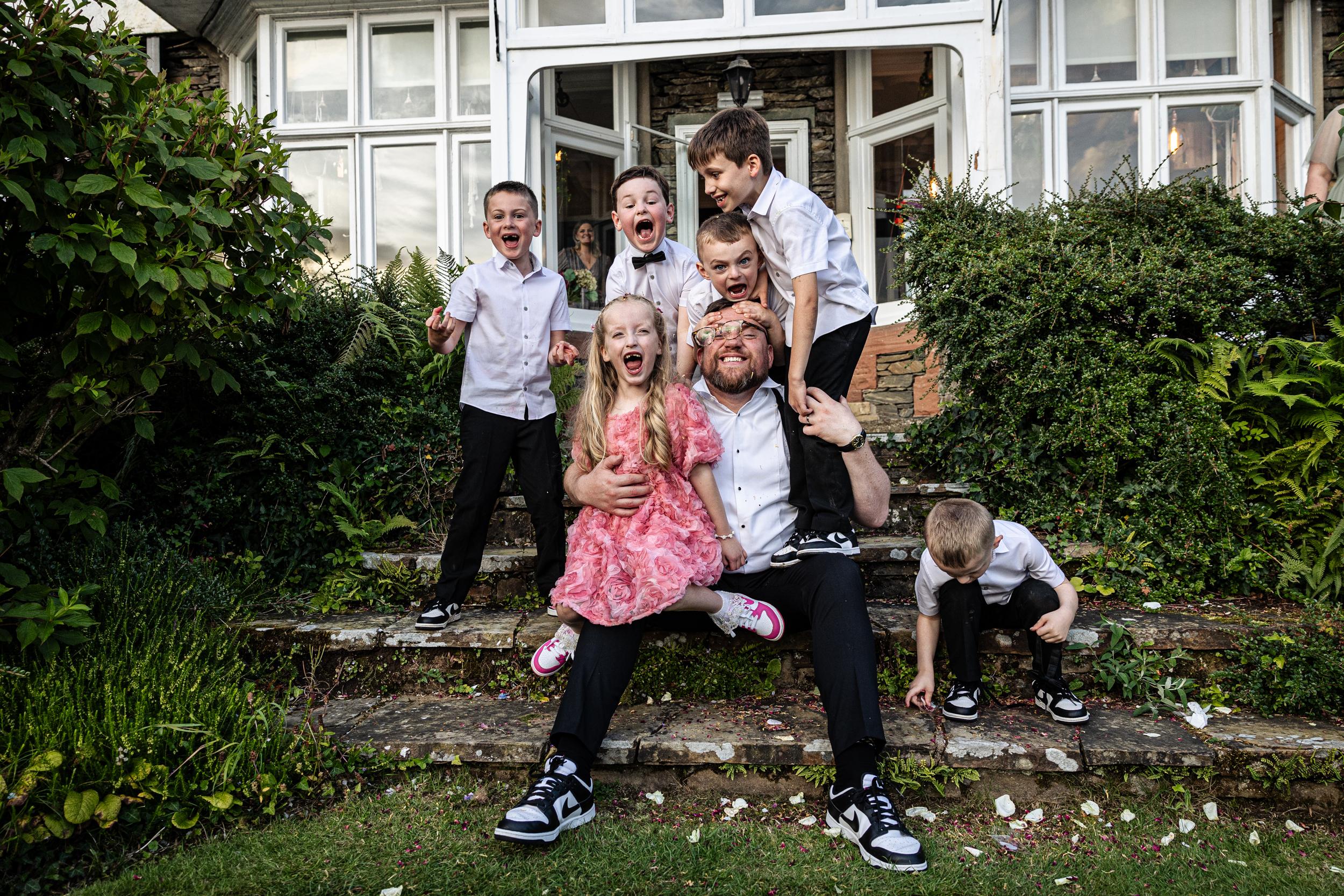 Non-Traditional Wedding Photography of kids and a groom on steps in a fun group shot